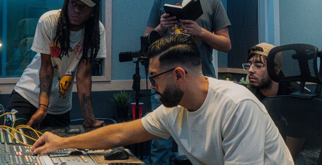 Matthew DeFreitas working on sound board with Bay Eight Sound Academy students