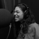 Miami Studio Woman in Gray Crew Neck Shirt Singing While Wearing Black Headphones Pexels Starter Cam 4387718