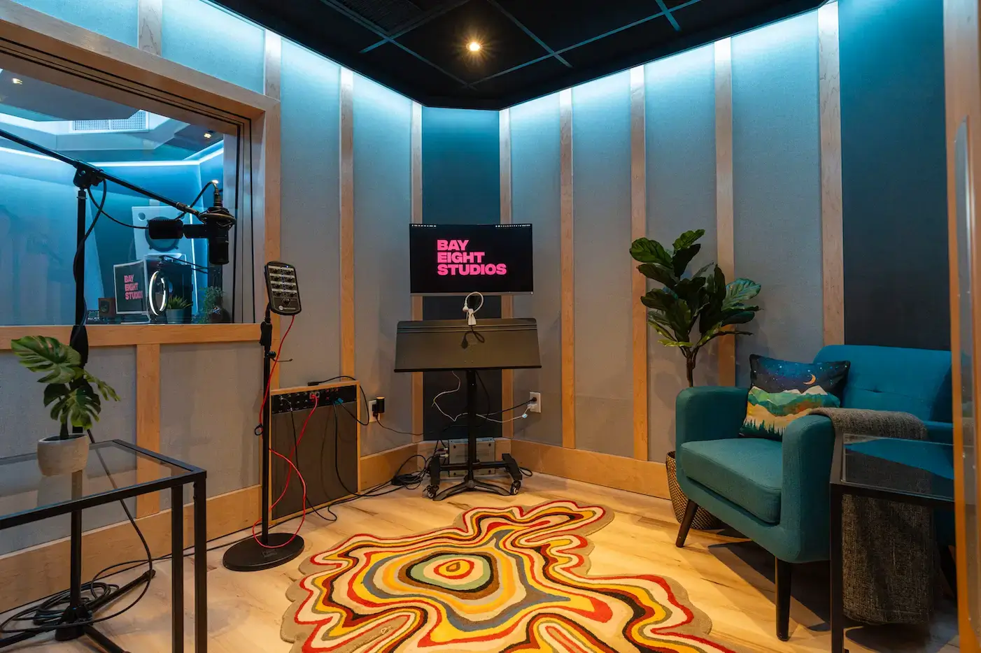 A modern music studio with a microphone, chair, and colorful rug creates a creative space for recording Taylor Swift songs.